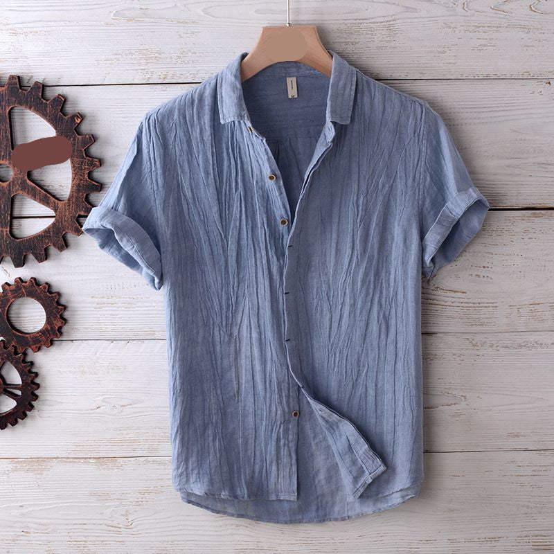 Blue short-sleeve shirt on a wooden surface with metal gears.
