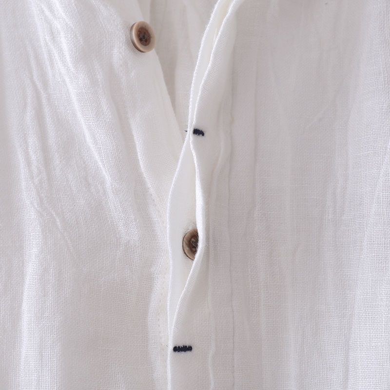 Close-up of a white shirt with buttons on a light gray background