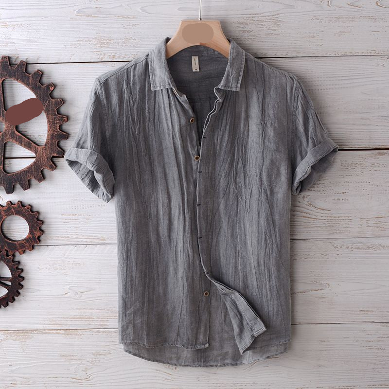 Gray short-sleeve shirt on a wooden surface with rustic elements