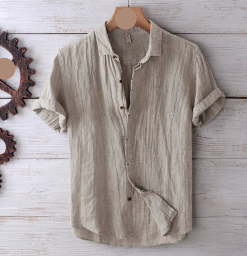 Beige striped shirt on a wooden hanger against a rustic wooden background